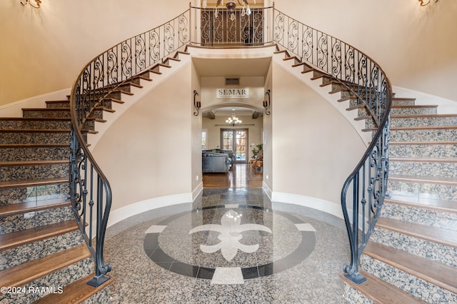 entryway featuring a towering ceiling and a chandelier