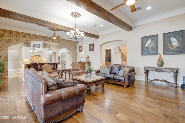 living room featuring ornamental molding, beam ceiling, ceiling fan with notable chandelier, and light wood-type flooring