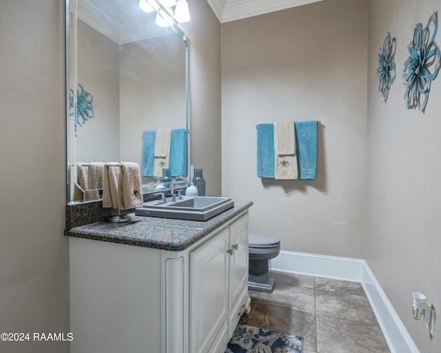 bathroom with toilet, crown molding, vanity, and tile patterned floors