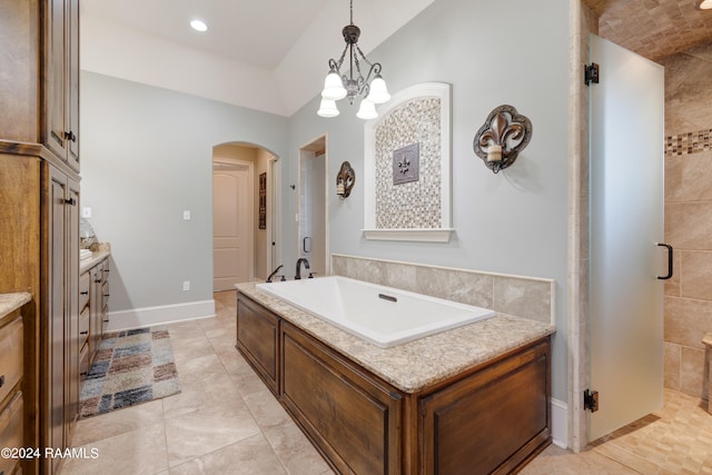 bathroom with vanity, a notable chandelier, independent shower and bath, and vaulted ceiling