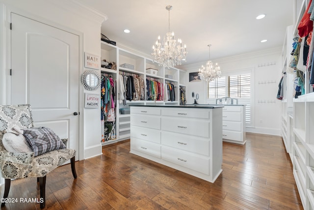 walk in closet featuring a chandelier and dark wood-type flooring