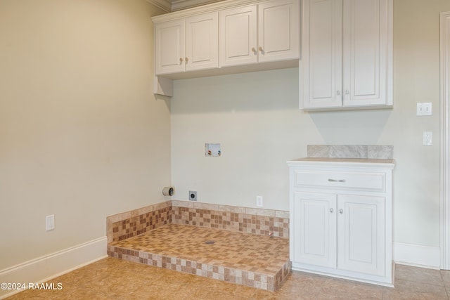 washroom with hookup for a washing machine, light tile patterned floors, and cabinets