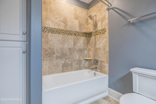 bathroom with tiled shower / bath, tile patterned floors, and toilet