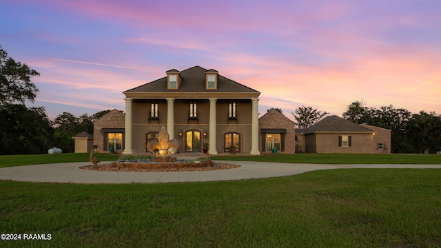 neoclassical home featuring a garage and a lawn