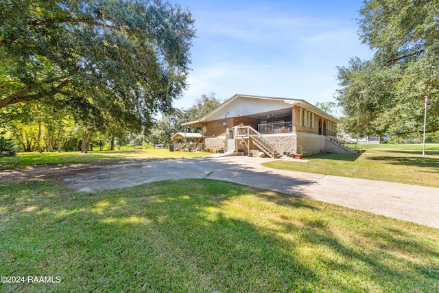 view of front facade with a sunroom and a front lawn