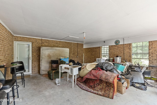 living room with brick wall, concrete flooring, and a wealth of natural light