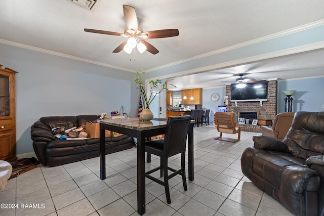 tiled living room featuring ornamental molding, a brick fireplace, and ceiling fan