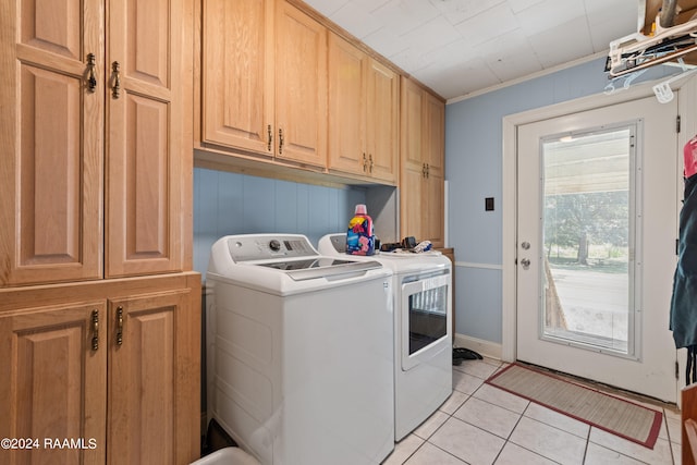 washroom with cabinets, crown molding, light tile patterned floors, and washing machine and dryer