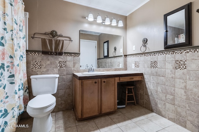 bathroom featuring tile walls, tile patterned floors, crown molding, vanity, and toilet