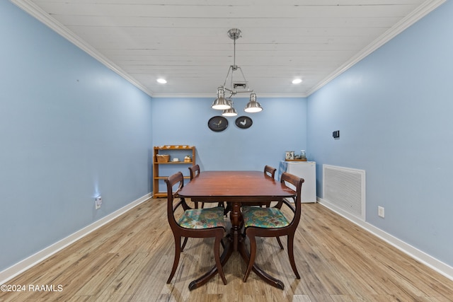 dining space featuring crown molding, light hardwood / wood-style floors, and an inviting chandelier