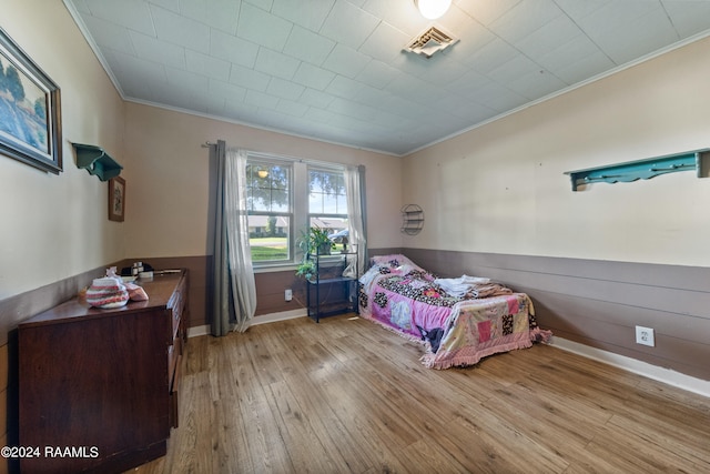 bedroom with light hardwood / wood-style flooring and crown molding