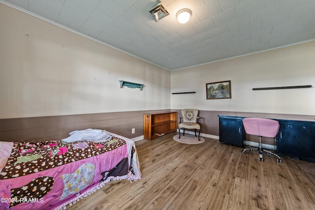 bedroom featuring wood-type flooring and crown molding