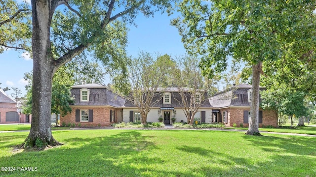 201 Canterbury Rd, Lafayette, LA 70508 - front of property featuring mansard roof, a front yard, and brick siding