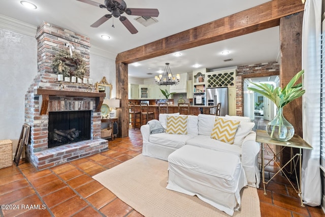 living room featuring ceiling fan with notable chandelier, beam ceiling, a fireplace, tile patterned floors, and ornamental molding