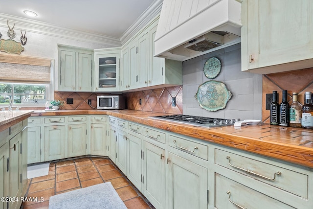 201 Canterbury Rd, Lafayette, LA 70508 - kitchen featuring range hood, stainless steel appliances, butcher block counters, decorative backsplash, and crown molding