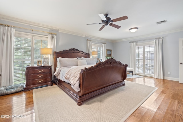 bedroom featuring ornamental molding, light wood-type flooring, and ceiling fan