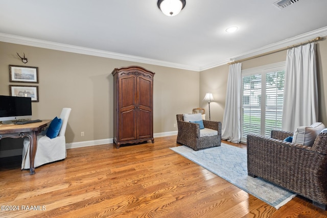 office area with light hardwood / wood-style floors and ornamental molding