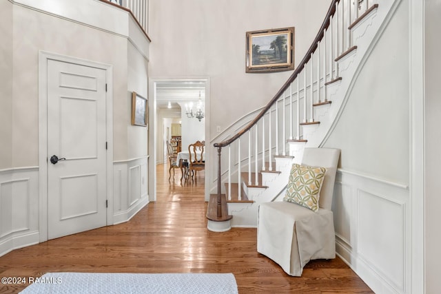 foyer entrance with hardwood / wood-style floors and a notable chandelier