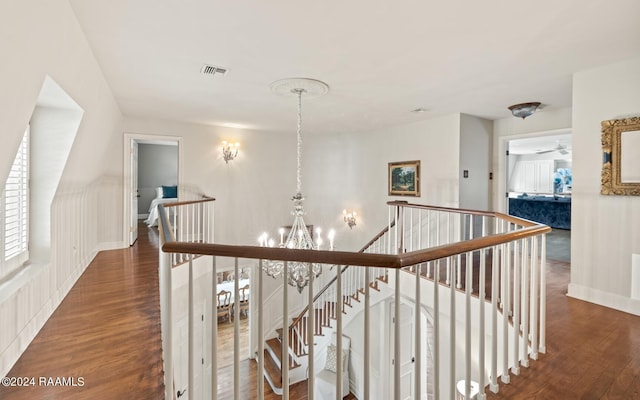 hall featuring a notable chandelier and dark hardwood / wood-style flooring