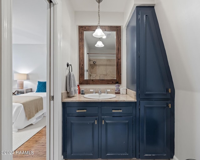 bathroom with wood-type flooring, vanity, and walk in shower