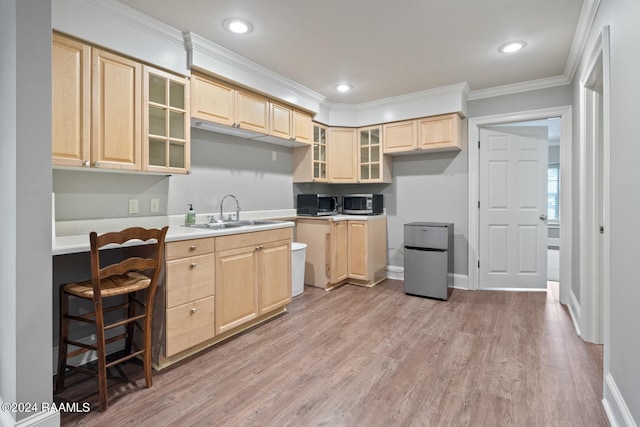 kitchen featuring sink, ornamental molding, stainless steel appliances, light brown cabinetry, and light wood-type flooring