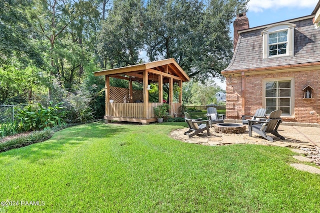 view of yard with a fire pit, a wooden deck, and a patio area