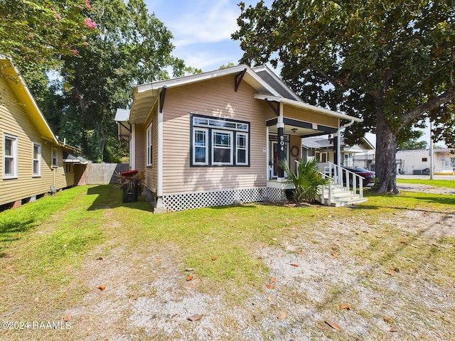 view of front of home with a porch and a front lawn