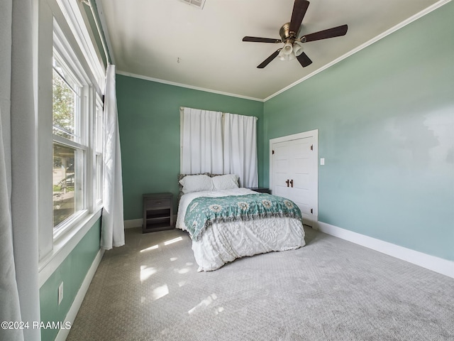 carpeted bedroom featuring ornamental molding and ceiling fan