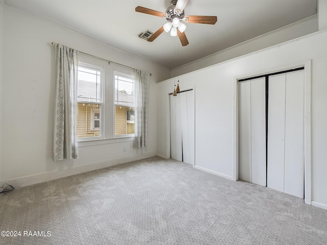 unfurnished bedroom with ceiling fan, ornamental molding, and carpet