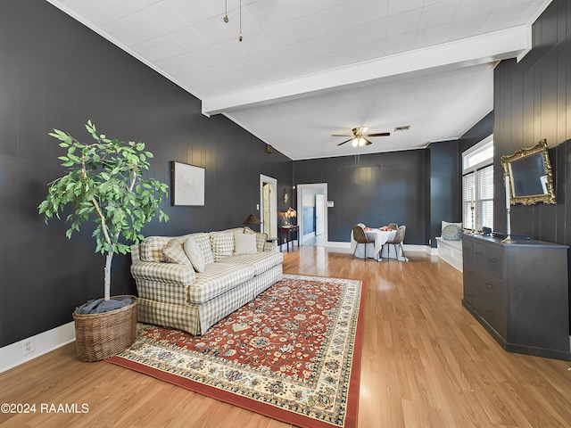 living room featuring vaulted ceiling with beams, wood walls, ceiling fan, and hardwood / wood-style flooring