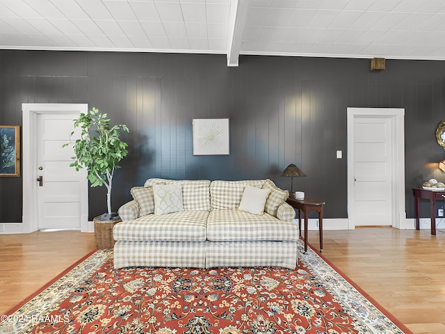 living room with light wood-type flooring, beam ceiling, and ornamental molding