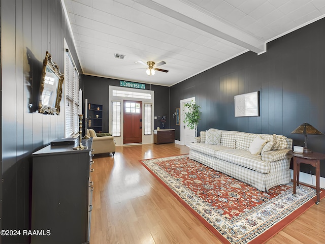 living room featuring beam ceiling, ceiling fan, hardwood / wood-style floors, and crown molding