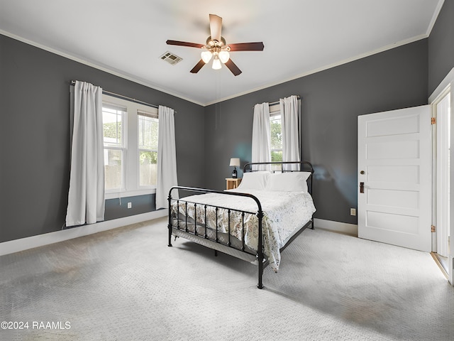 carpeted bedroom featuring ceiling fan and crown molding