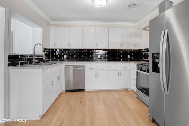 kitchen featuring white cabinets, sink, stainless steel appliances, light wood-type flooring, and crown molding