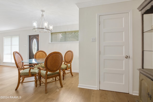 dining space with light wood-type flooring, crown molding, and a chandelier