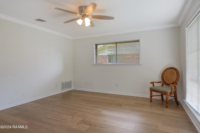 empty room featuring ceiling fan, light wood-type flooring, and ornamental molding