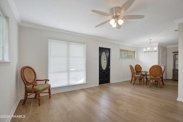 foyer entrance with crown molding, light hardwood / wood-style floors, and ceiling fan with notable chandelier