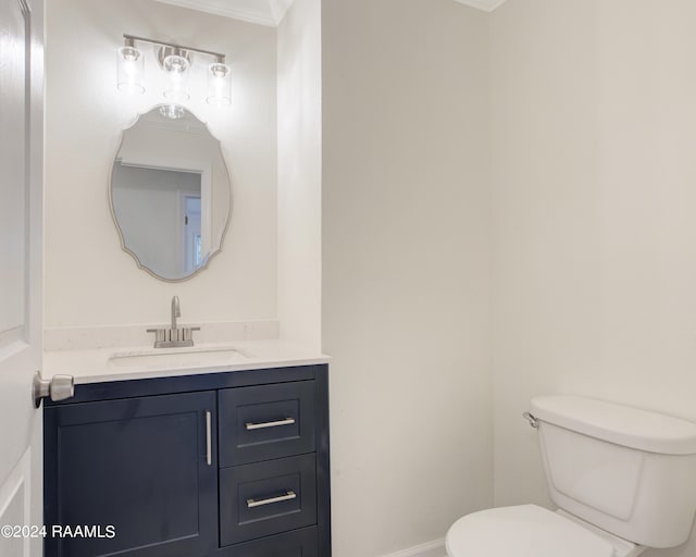 bathroom featuring crown molding, vanity, and toilet