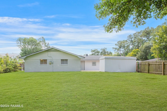 rear view of house featuring a lawn