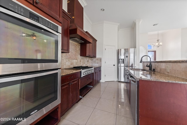 kitchen with a chandelier, sink, custom range hood, appliances with stainless steel finishes, and light tile patterned floors