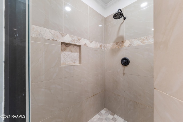 bathroom featuring crown molding and tiled shower