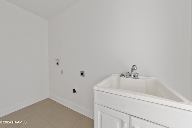 clothes washing area with hookup for a washing machine, hookup for an electric dryer, light tile patterned floors, cabinets, and sink