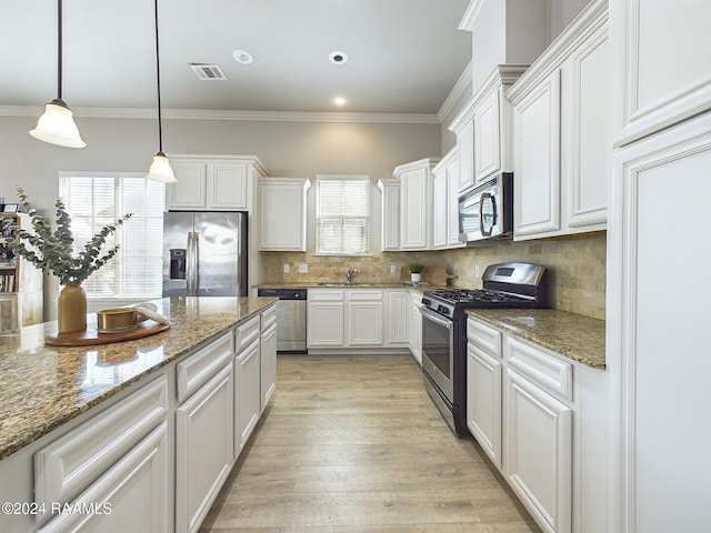 102 Rue Gambetta, Lafayette, LA 70507 - kitchen featuring appliances with stainless steel finishes, a sink, plenty of natural light, ornamental molding, and backsplash