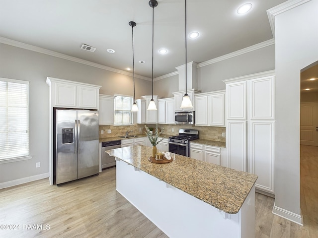 102 Rue Gambetta, Lafayette, LA 70507 - kitchen featuring appliances with stainless steel finishes, a sink, white cabinets, a center island, and backsplash