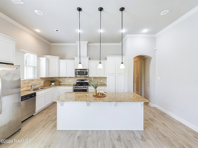 kitchen featuring stainless steel appliances, pendant lighting, light hardwood / wood-style flooring, white cabinets, and a center island