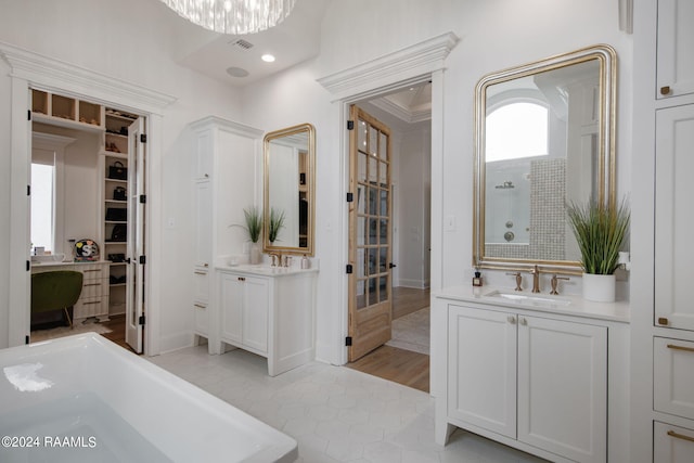 bathroom featuring ornamental molding, wood-type flooring, independent shower and bath, and vanity