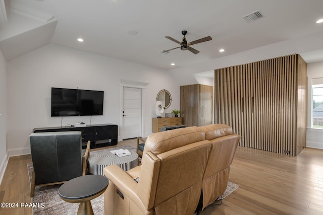 living room featuring ceiling fan, vaulted ceiling, and light hardwood / wood-style floors