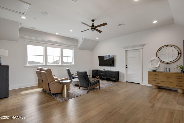 living room with lofted ceiling, ceiling fan, and light hardwood / wood-style flooring