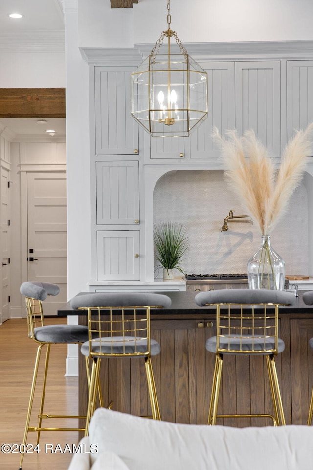 dining area featuring ornamental molding, wood-type flooring, and an inviting chandelier