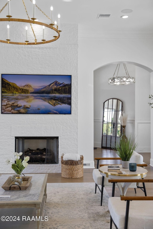 living room with a brick fireplace and hardwood / wood-style flooring